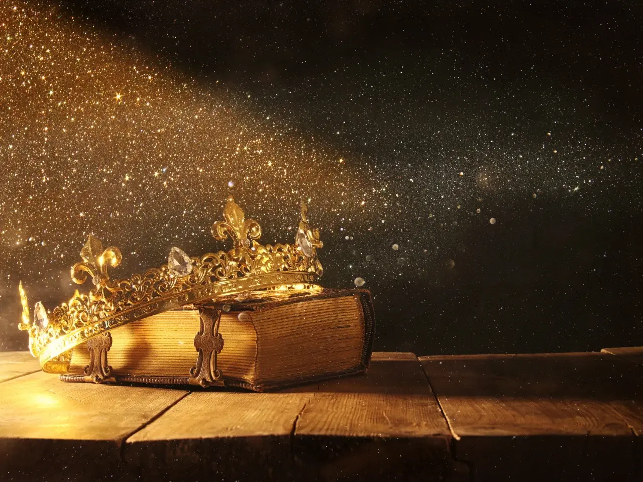 Vintage crown resting on an old book representing medieval fantasy worlds and fictional language creation.