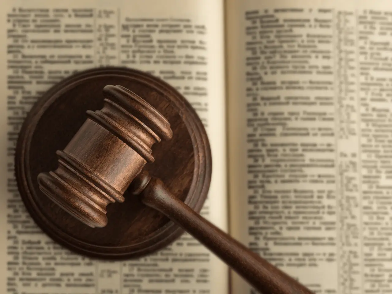 Wooden judge’s gavel resting on an open book, symbolizing Quebec’s business language laws and legal compliance.