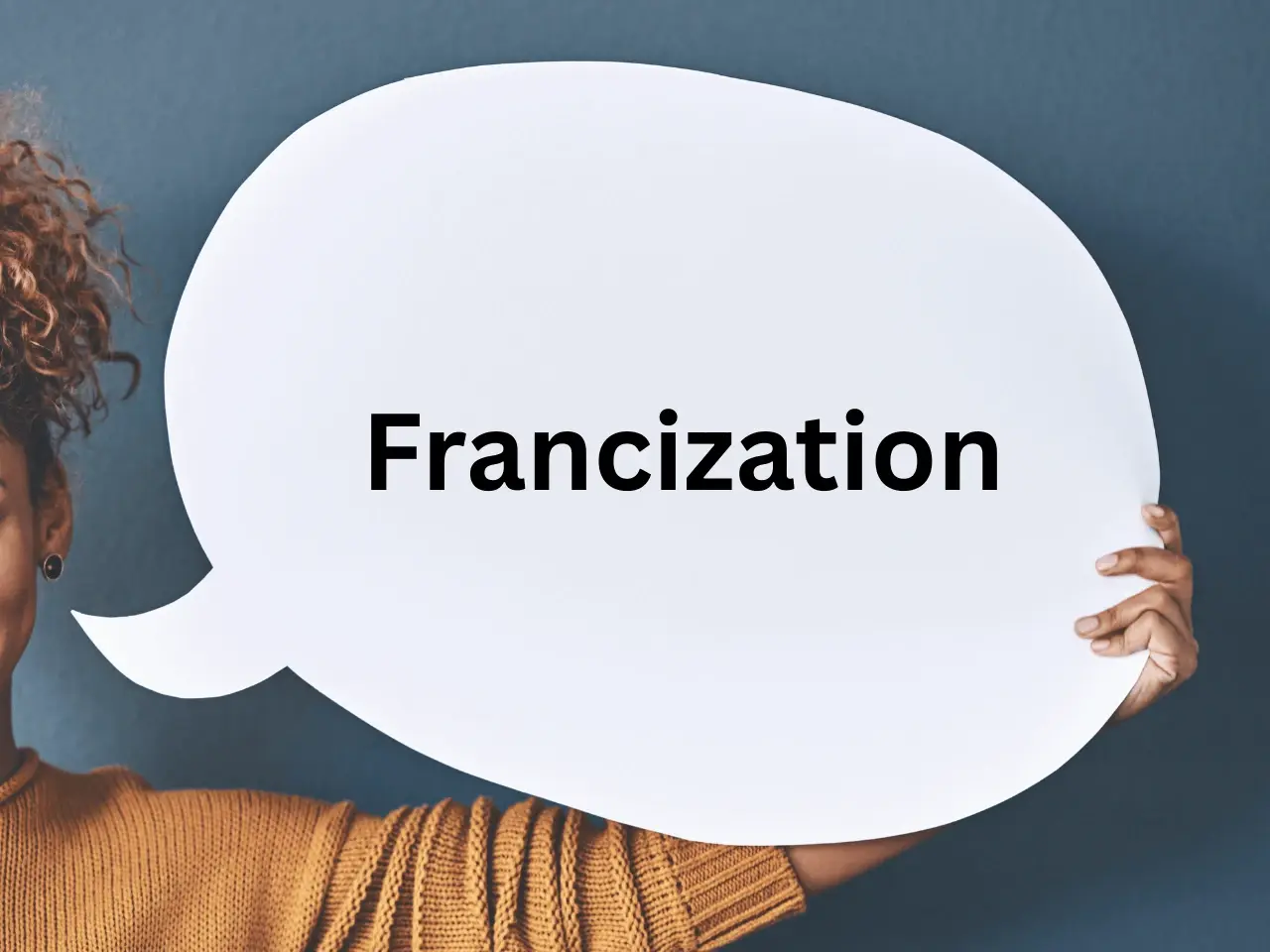 Person holding a large white speech bubble with the word Francization written in bold, symbolizing Quebec’s requirement for businesses to integrate French into workplace and communication practices.