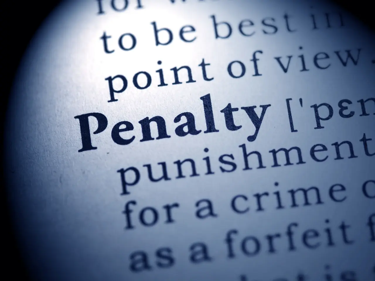 Close-up of the word “Penalty” in a dictionary, highlighting consequences of non-compliance with Quebec’s language laws.
