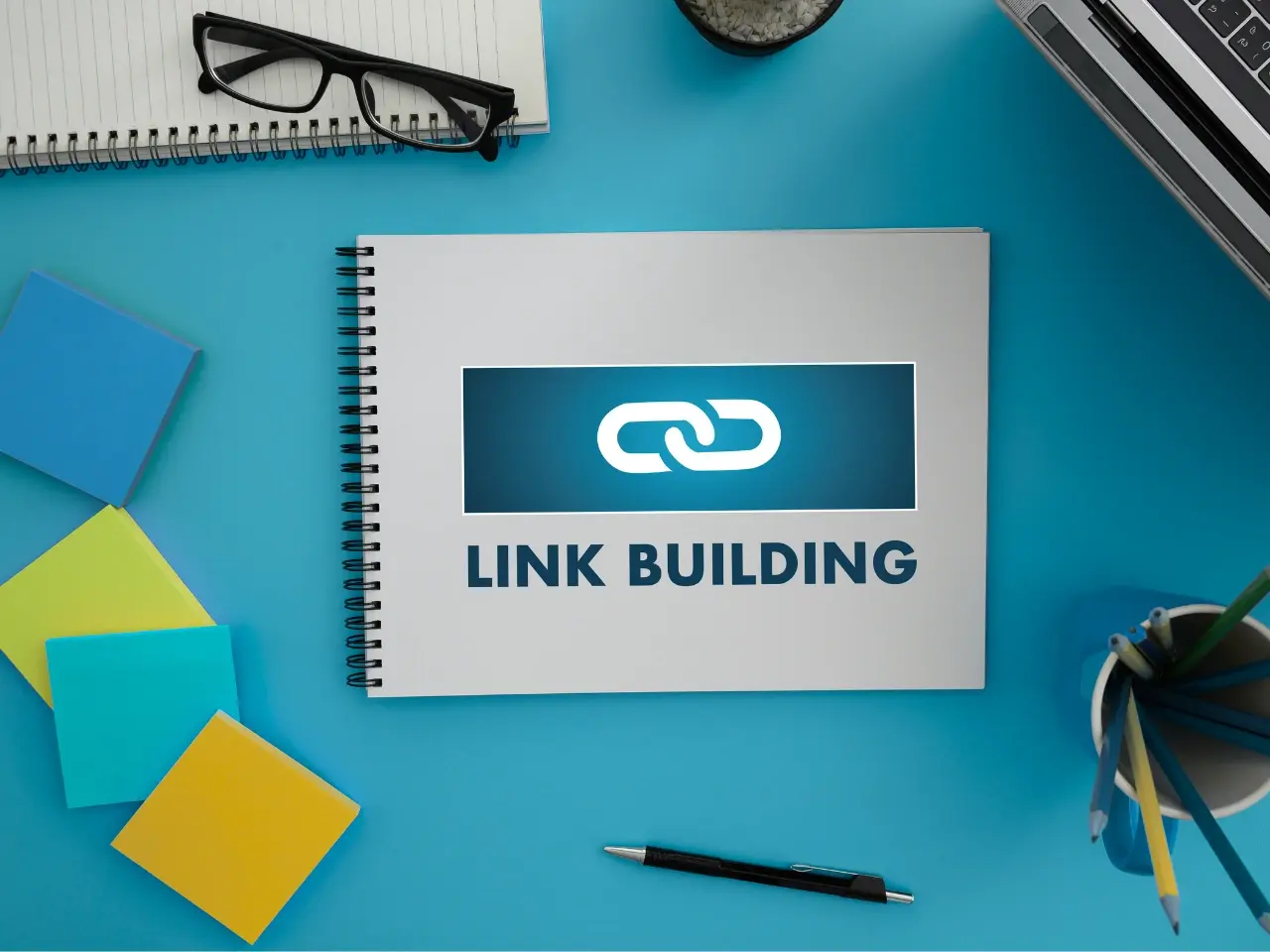 Workspace with “Link Building” graphic highlighting local authority and international backlink strategy.