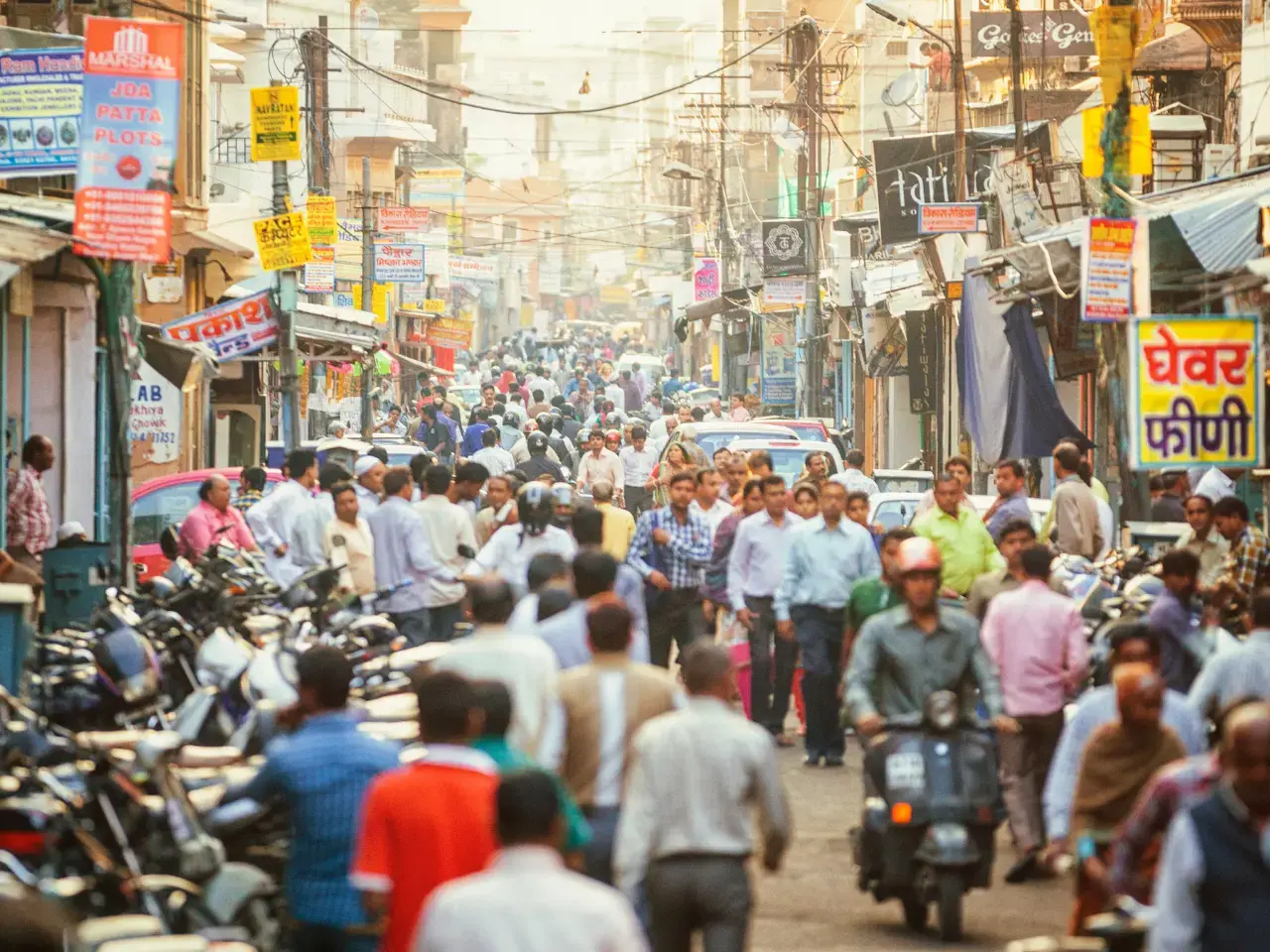 A busy street scene in India showing people talking to each other in their own languages.
