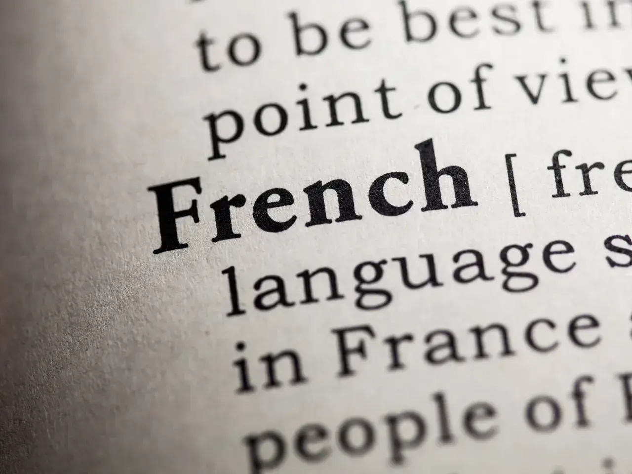 Close-up of the word French in a dictionary, highlighting the importance of the French language in Quebec compliance laws.
