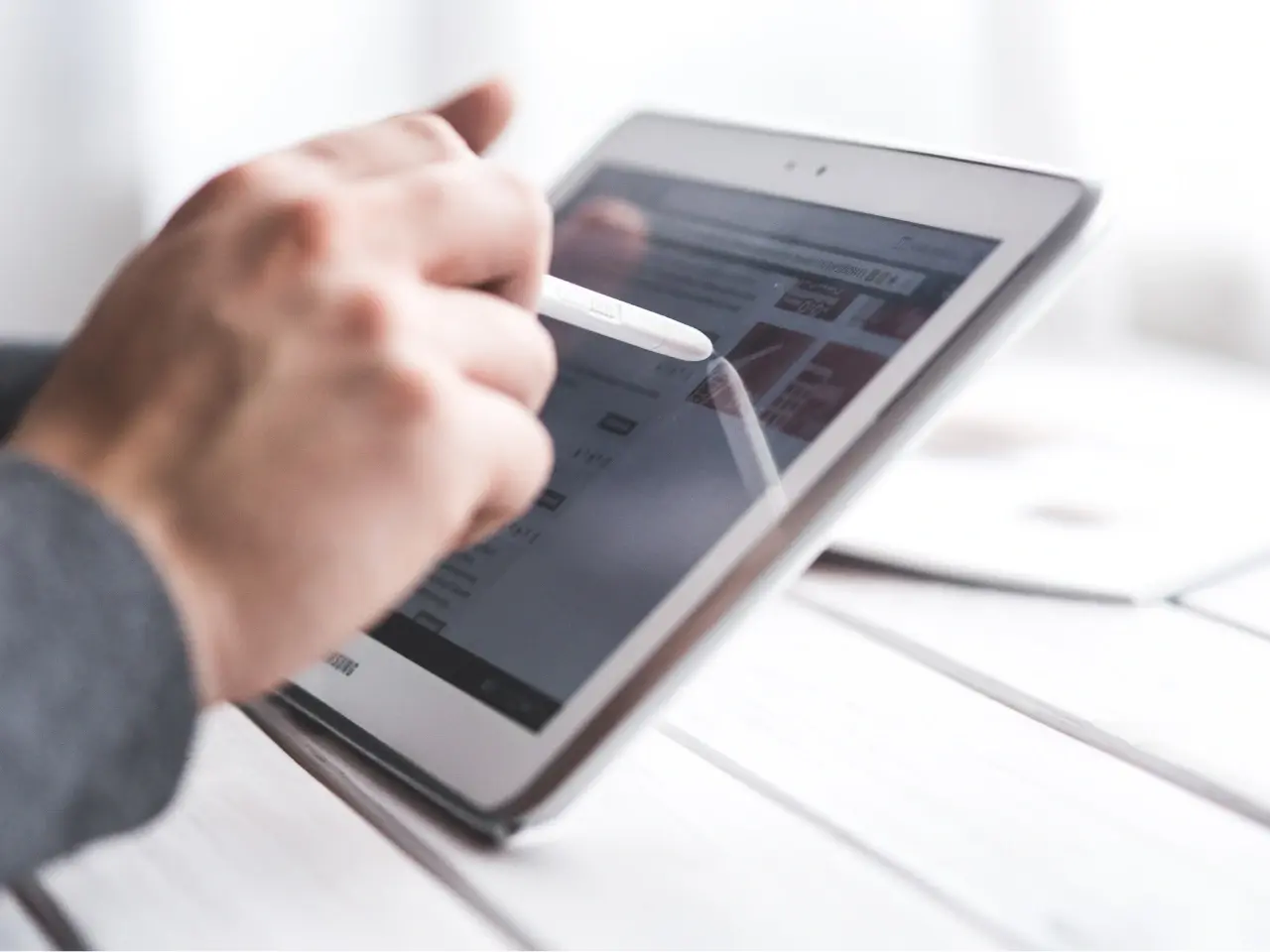Person translating content on a tablet, symbolizing how the Shopify Translate & Adapt app works.