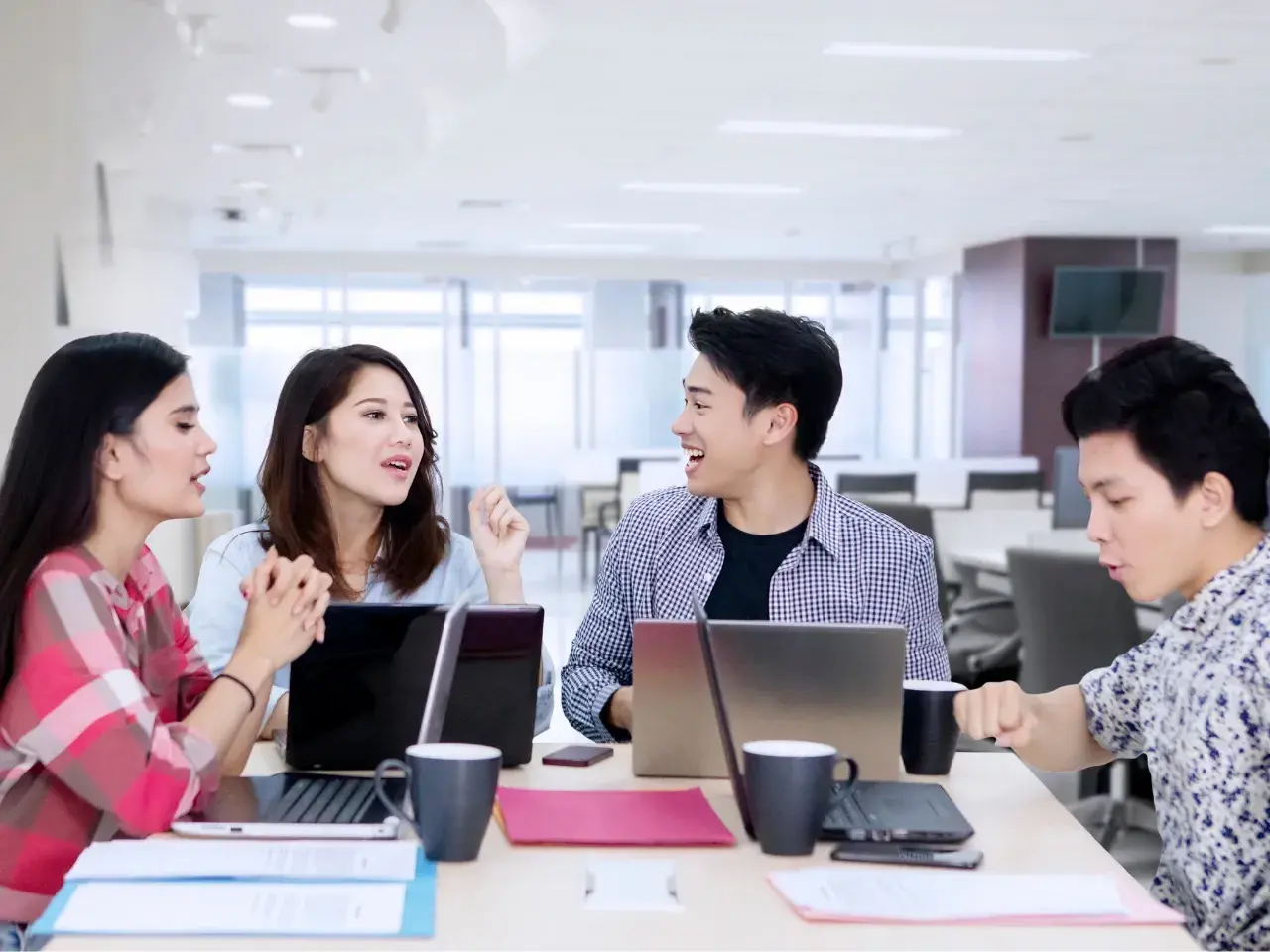 A multilingual team meeting in an office, with Chinese translation for business growth.