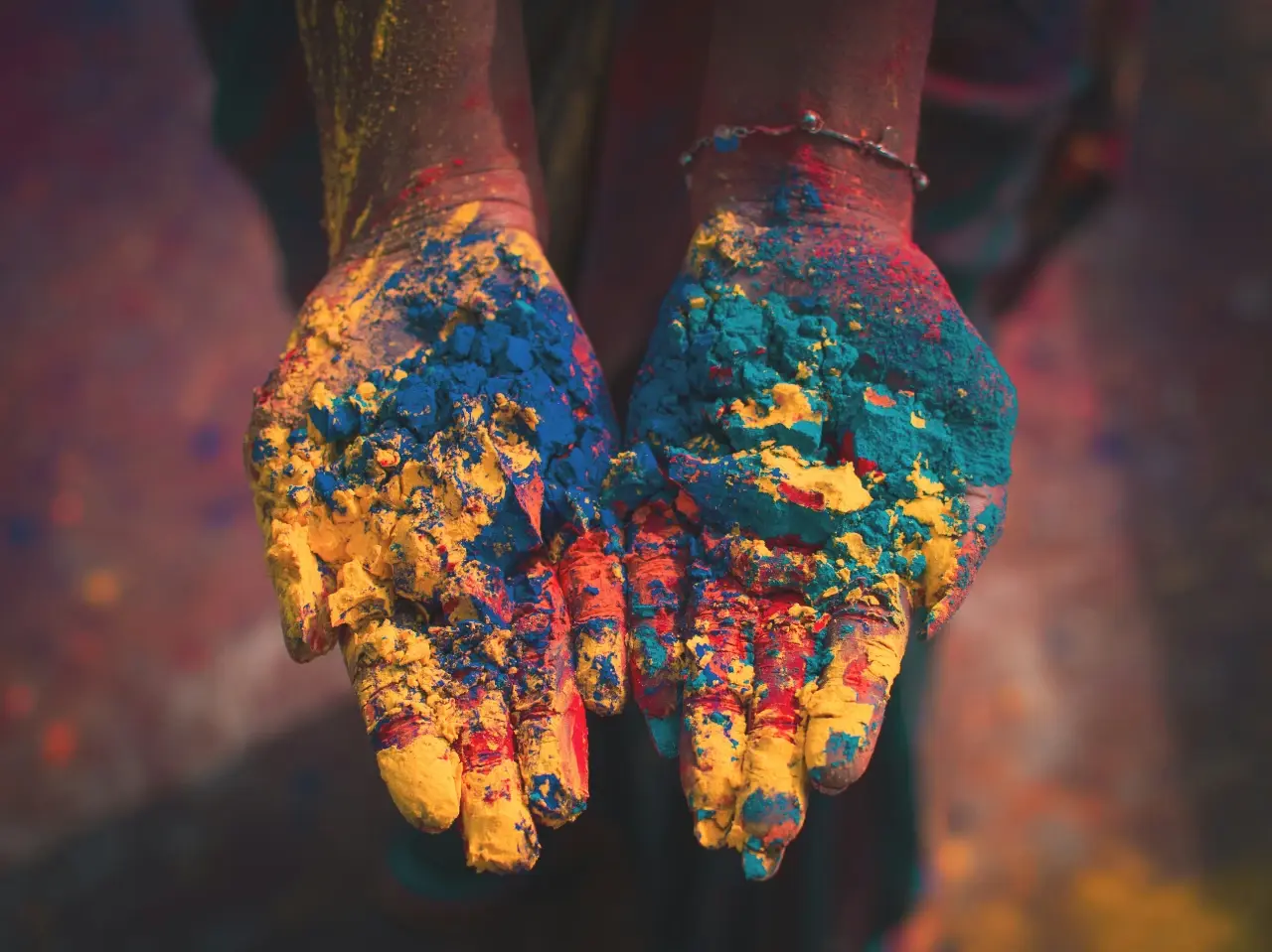 Hands covered in colourful powder symbolizing cultural and linguistic diversity beyond statistics in Canada.