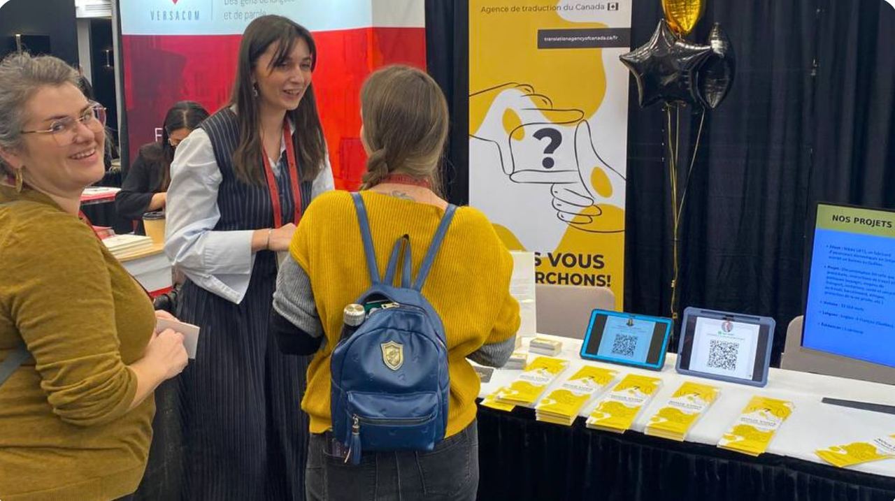 Translation Agency of Canada team member speaking with a visitor at the booth during the OTTIAQ Congress 2024