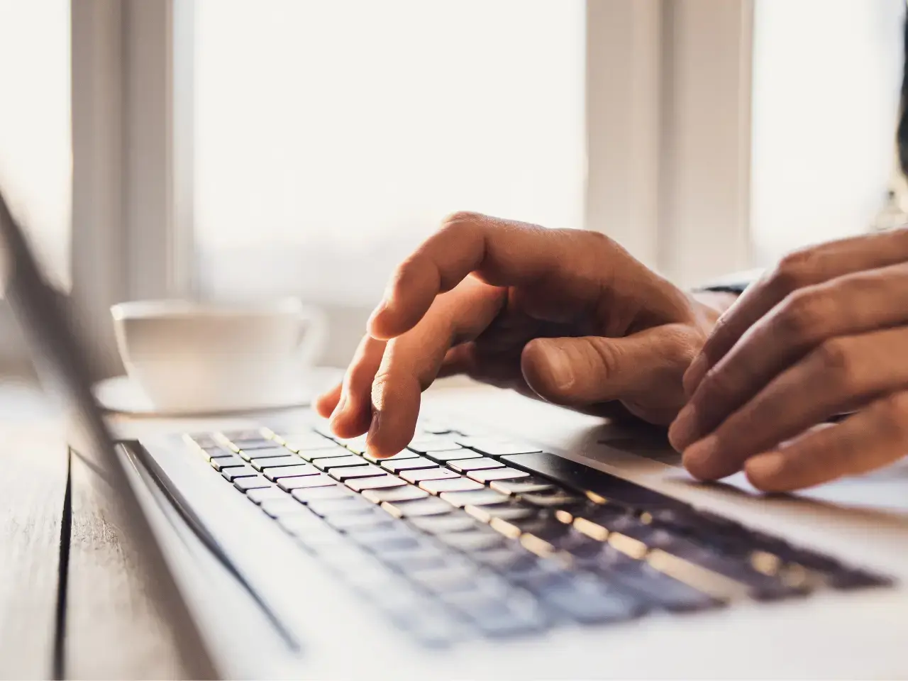 Editor typing corrections on a laptop to improve MT output during light or full post-editing.