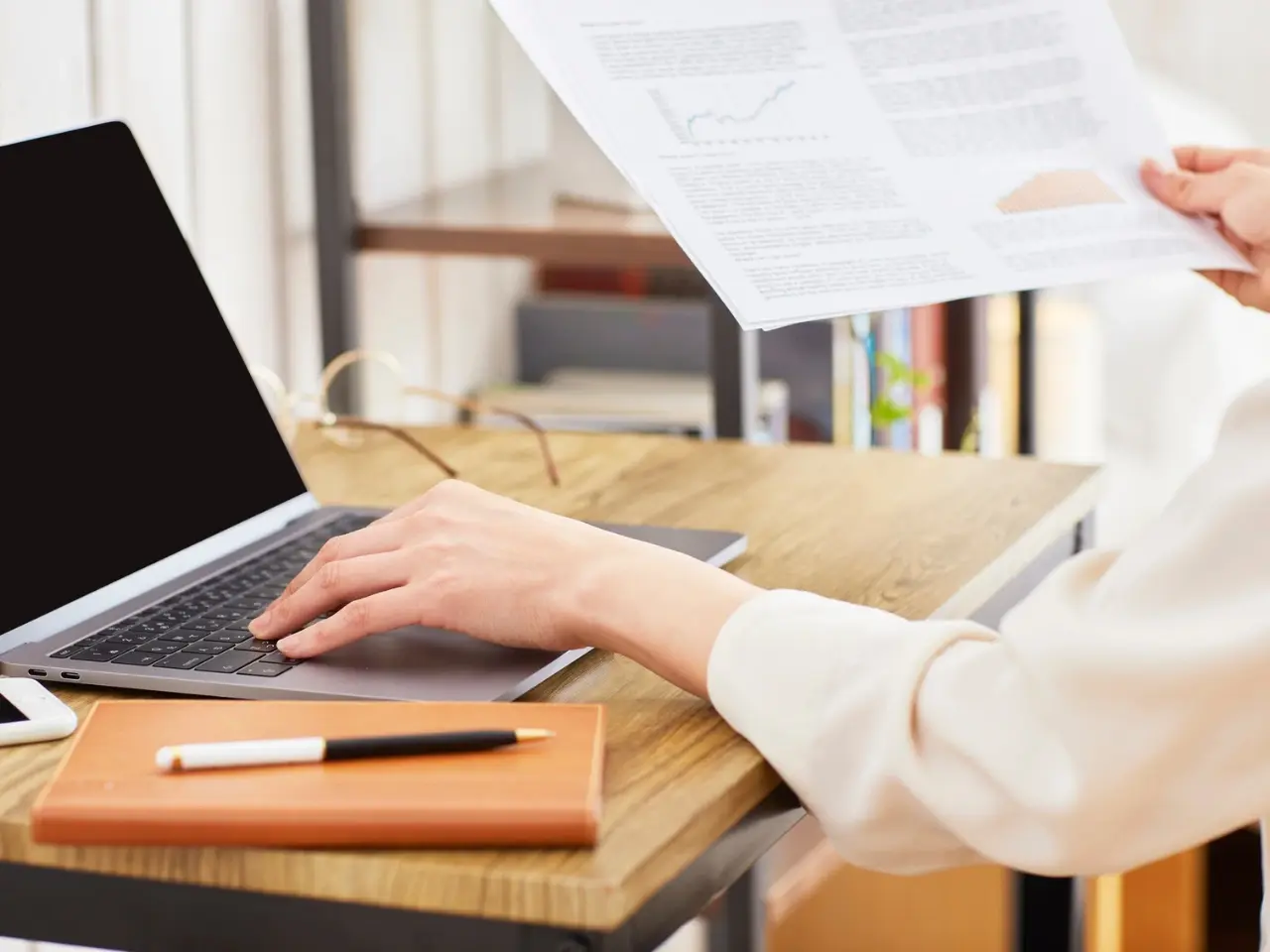 A professional linguist reviewing translation notes and marketing documents at a desk.