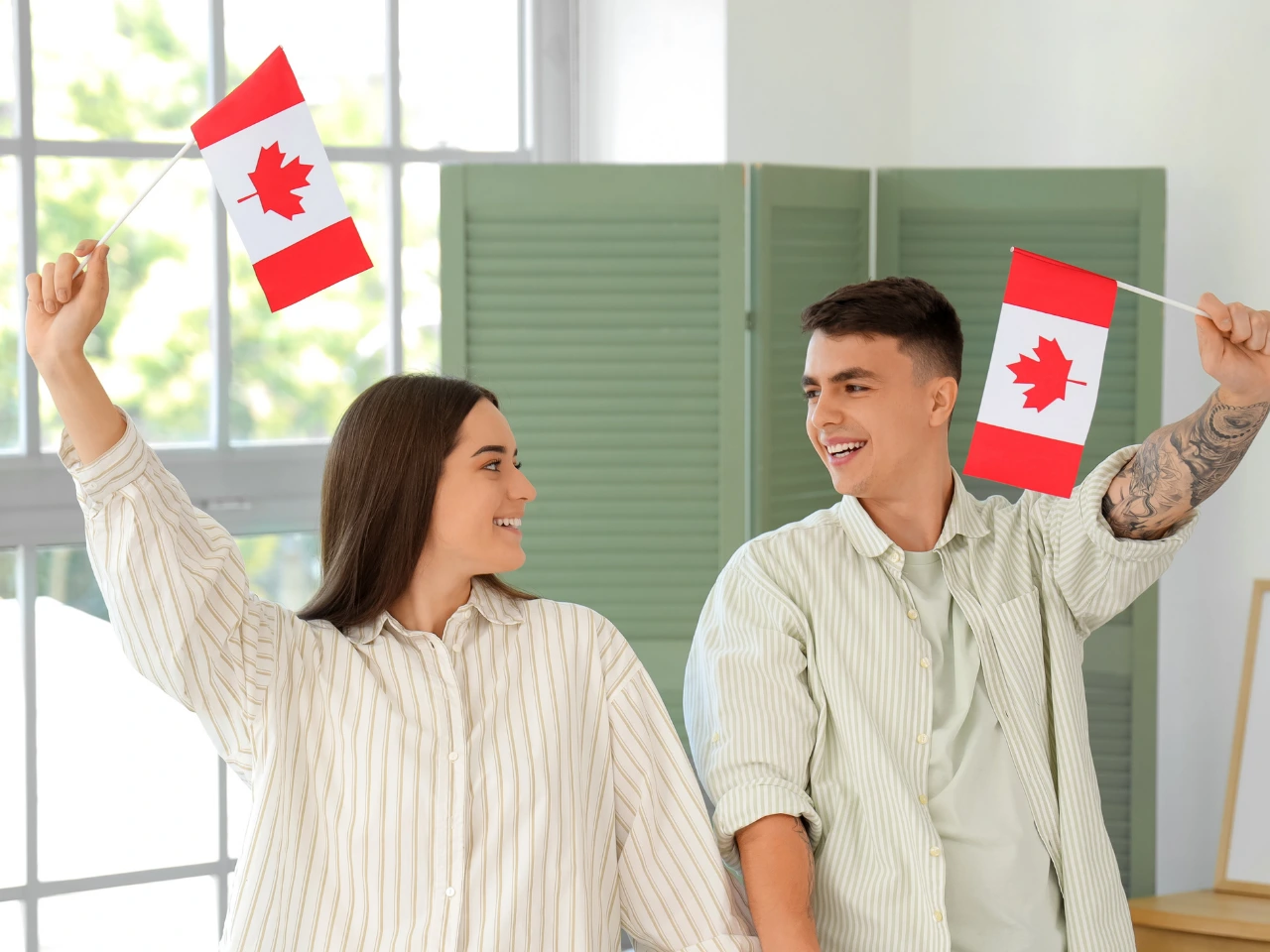 Family celebrating Canadian citizenship with Canadian flags.