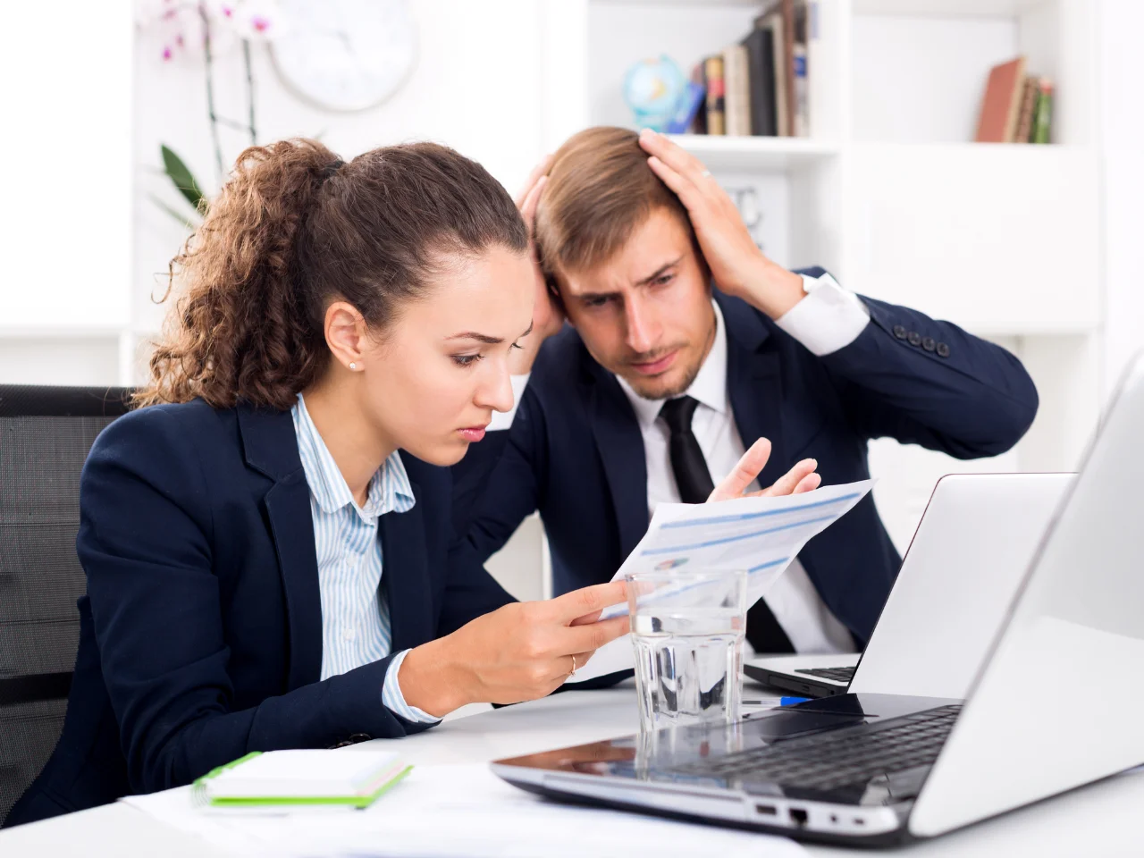 Business professionals reviewing email marketing documents after identifying CASL compliance mistakes.