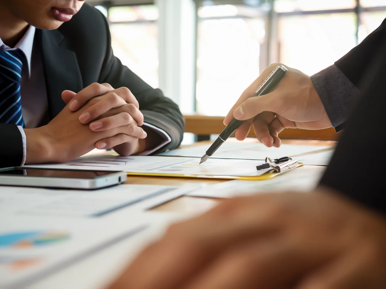 Business professionals reviewing a certificate of origin in Canada and export documents for international trade compliance.