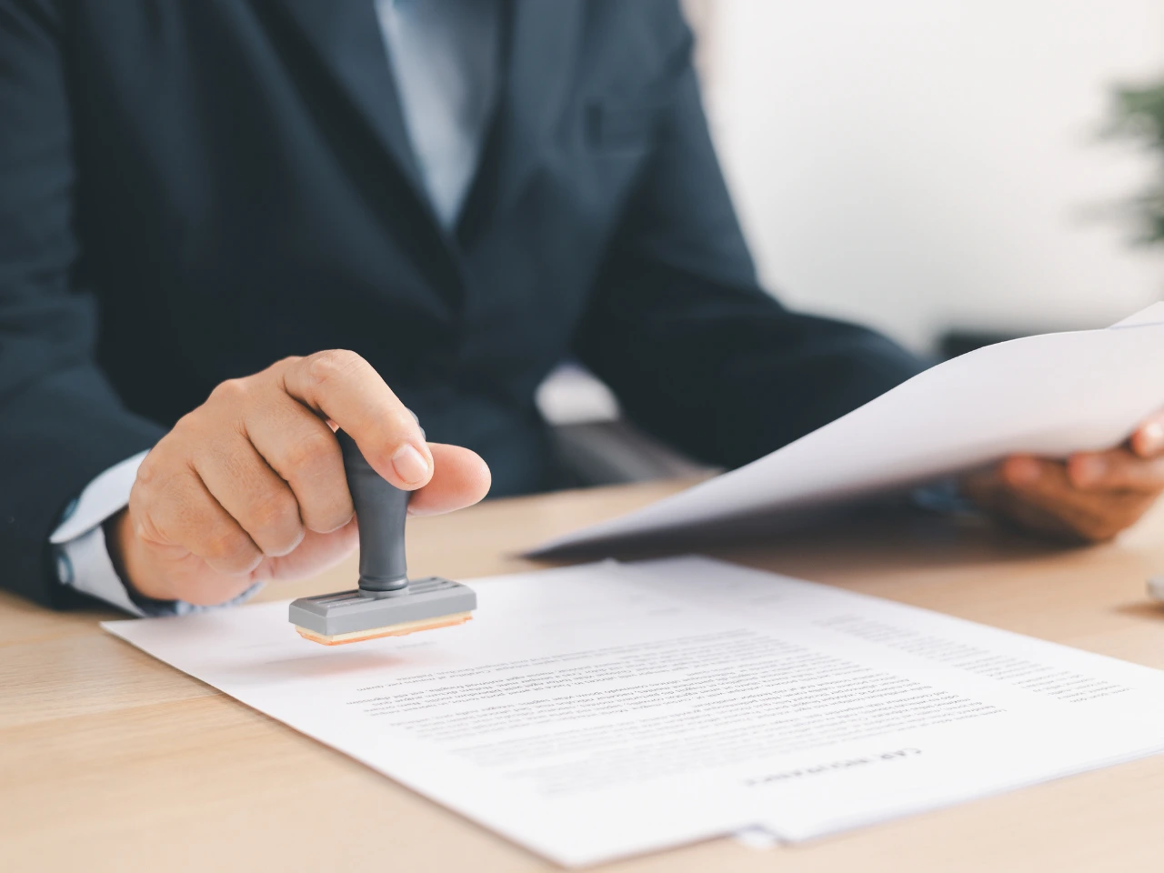 Exporter stamping commercial documents before issuing a CETA origin declaration.