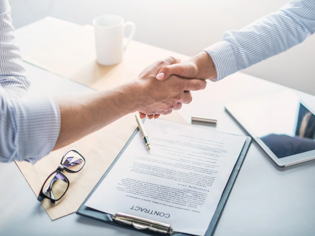Employer and employee reaching an agreement after reviewing an employment contract.