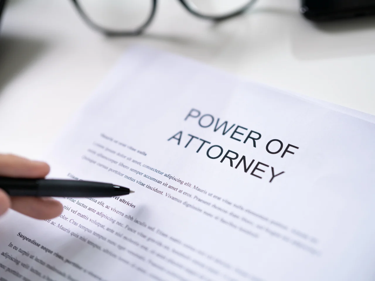 Person reviewing and signing an international power of attorney document for notarization and use abroad.