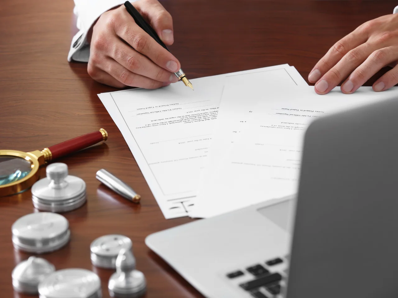 Individual signing a document in front of a notary public.