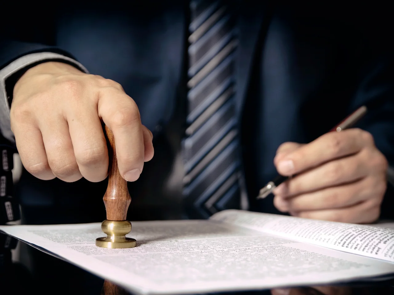 Professional applying an official seal to a document during notarization or authentication services.