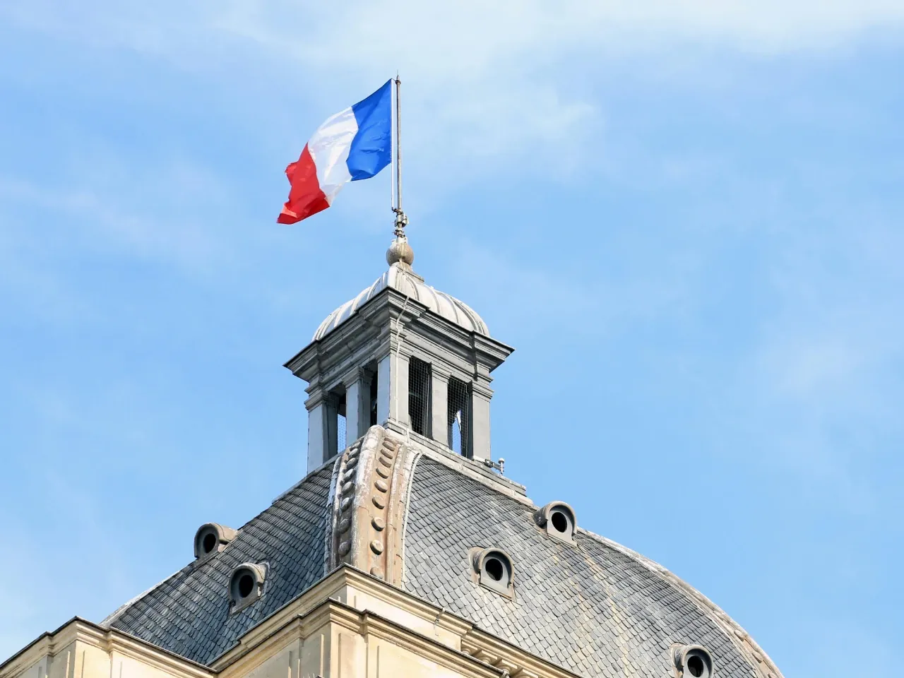 French flag flying above government building in Quebec.