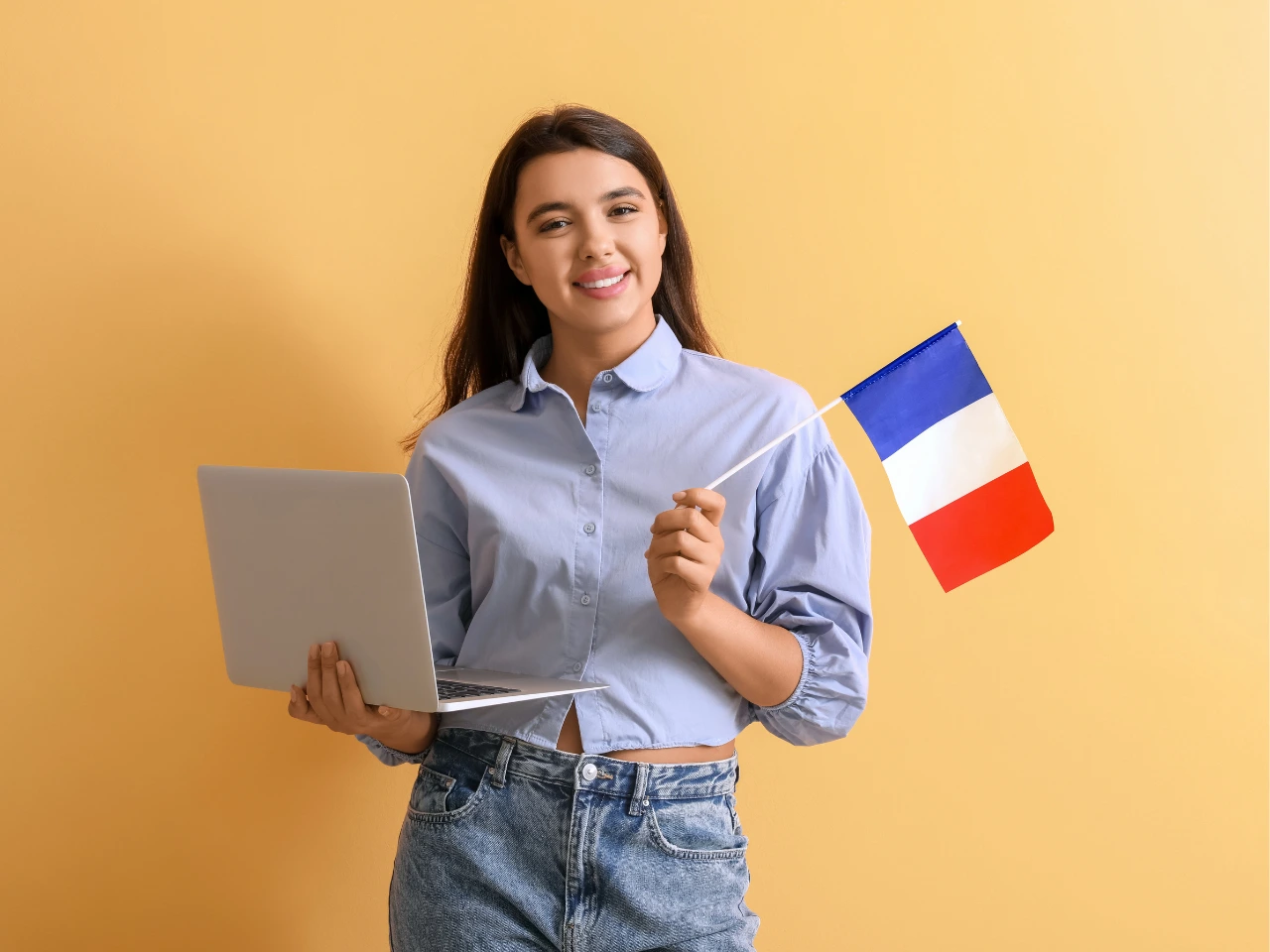 Person holding French flag representing French language education.