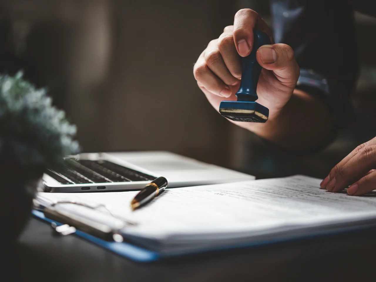 Person stamping legal documents before apostille and legalization.
