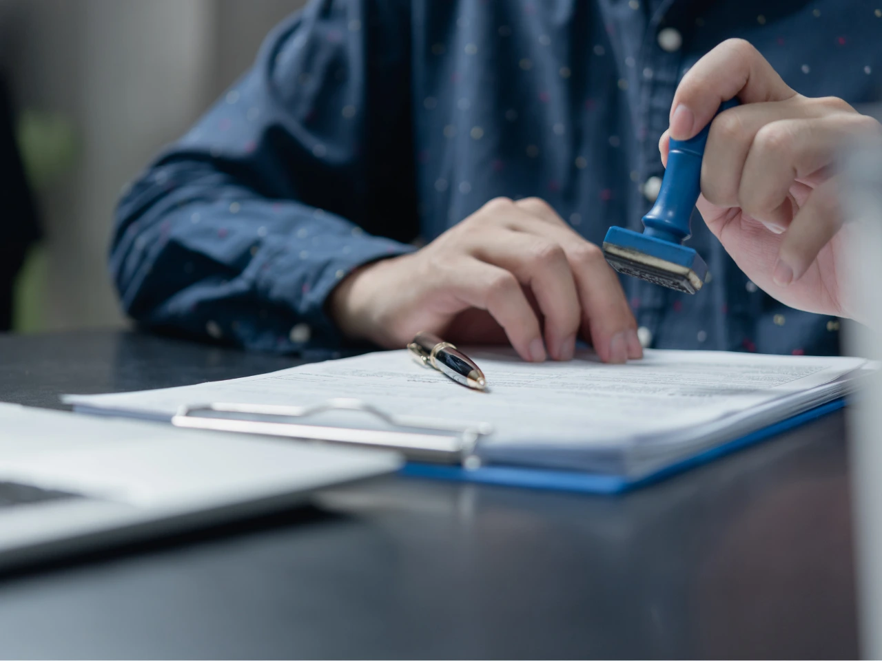 Authorized person stamping a photocopy after comparing it with the original document